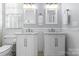 Stylish bathroom featuring dual vanities, framed mirrors, and white cabinets at 14111 Garden District Row, Huntersville, NC 28078