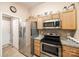 Kitchen boasts stainless steel appliances and wood cabinets at 3012 Viola Ln, Monroe, NC 28110