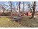 Backyard with grass, bare trees, a picnic table, fire pit, and small red storage shed at 3257 Westridge Sw Ln, Concord, NC 28027