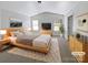 Virtually staged main bedroom with wood-look flooring and large windows at 3744 Amber Meadows Dr, Charlotte, NC 28269