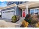House exterior showcasing gray siding, red front door, and stone accents at 6270 Durango Way, Denver, NC 28037