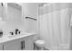 Modern bathroom with white fixtures, black hardware, sleek vanity, and shower with chevron curtain at 712 Georgie St, Troutman, NC 28166