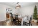 Cozy dining area featuring wood floors, modern light fixture, seating for four, and a glimpse of the adjacent kitchen at 712 Georgie St, Troutman, NC 28166