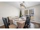 Inviting dining room with a modern chandelier, a dining table set for a meal, and a cushioned bench at 712 Georgie St, Troutman, NC 28166