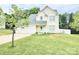 Charming two-story home with a well-maintained lawn, attached garage, and quaint front porch with rocking chairs at 712 Georgie St, Troutman, NC 28166