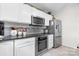 Modern kitchen with stainless steel appliances, white cabinetry, dark countertops, and tile backsplash at 712 Georgie St, Troutman, NC 28166