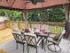 Relaxing outdoor dining area featuring a gazebo, table with six chairs, and a hot tub nearby at 712 Georgie St, Troutman, NC 28166
