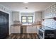 Modern kitchen with white cabinets, geometric wallpaper, and stainless steel appliances at 913 S Franklin St, China Grove, NC 28023