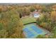 Aerial view of tennis courts next to a clubhouse, swimming pool and surrounded by wooded, colorful trees at 10015 Lattice Ct, Charlotte, NC 28269