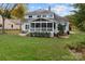 Large backyard view of the home and screened porch featuring a well-maintained lawn at 10015 Lattice Ct, Charlotte, NC 28269