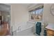 Bright bathroom with soaking tub, chrome towel rack with teal towels, and window with valance at 10015 Lattice Ct, Charlotte, NC 28269