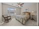 Bedroom featuring large window, ceiling fan, and quaint rocking chair at 10015 Lattice Ct, Charlotte, NC 28269