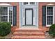 A lovely red brick staircase leads up to the front door flanked by black shuttered windows at 10015 Lattice Ct, Charlotte, NC 28269