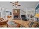 Cozy living room features a brick fireplace, ceiling fan, and access to the staircase at 10015 Lattice Ct, Charlotte, NC 28269