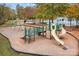 Community playground featuring swings, slides, and climbing structures on a wood chip surface at 10015 Lattice Ct, Charlotte, NC 28269