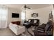 Living room with light-colored sofas, a ceiling fan, and a large TV at 15209 Red Canoe Way, Charlotte, NC 28278