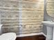 Powder room with wood-like wallcovering, white sink and toilet at 15305 Colonial Park Dr, Huntersville, NC 28078