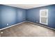 Blue bedroom with carpet and three windows at 15305 Colonial Park Dr, Huntersville, NC 28078