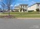 Two-story house with light green siding and a landscaped yard at 15305 Colonial Park Dr, Huntersville, NC 28078