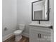 Modern powder room with wood look floor, white vanity, and brushed bronze faucet at 1852 Yardley St, Rock Hill, SC 29732