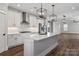 Bright kitchen features an island, stainless steel appliances, white cabinets, modern light fixtures, and hardwood floors at 1852 Yardley St, Rock Hill, SC 29732