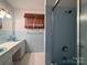 Bathroom featuring a shower, sink and light-blue tiled walls at 202 Cedar St, Belmont, NC 28012