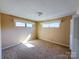 Bedroom featuring beige walls, stained carpet and two windows at 202 Cedar St, Belmont, NC 28012