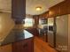 Modern kitchen featuring stainless steel appliances, dark wood cabinets, and granite countertops at 202 Cedar St, Belmont, NC 28012