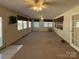 Spacious living room with carpet floors, many windows, and two ceiling fans at 202 Cedar St, Belmont, NC 28012