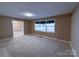 Living room with beige walls, stained carpet and a window at 202 Cedar St, Belmont, NC 28012