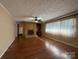 Open living room featuring hardwood floors, brick fireplace, and large window at 202 Cedar St, Belmont, NC 28012