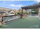 A picturesque backyard featuring a putting green, a pool, and a pergola with stone pillars at 209 Choate Ave, Fort Mill, SC 29708