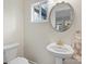 Powder room boasts a pedestal sink with a round mirror and neutral decor at 209 Choate Ave, Fort Mill, SC 29708