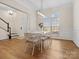 Bright dining room boasts hardwood floors, natural light, modern lighting fixture and ornate white chairs at 209 Choate Ave, Fort Mill, SC 29708