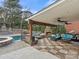 Inviting covered outdoor living space with a stone fireplace, comfortable seating, ceiling fans, and a view of the pool at 209 Choate Ave, Fort Mill, SC 29708