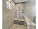 Updated tiled shower with a glass door and shower bench offers a luxurious spa-like experience at 209 Choate Ave, Fort Mill, SC 29708