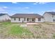 Rear exterior of home featuring a covered back patio, lush lawn, and mature trees at 2213 Genesis Dr, Monroe, NC 28110