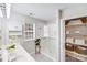 Bright, clean bathroom featuring a double sink, shower, window and open shelving at 2213 Genesis Dr, Monroe, NC 28110