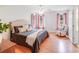 Cozy bedroom features three windows, ceiling fan, wood floors, a bed, and accent chair at 2213 Genesis Dr, Monroe, NC 28110