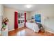 Comfortable bedroom featuring a bright window with red curtains, hardwood floors, and stylish decor at 2213 Genesis Dr, Monroe, NC 28110