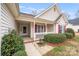 Inviting front porch with red shutters and white railings, featuring a cozy seating area at 2213 Genesis Dr, Monroe, NC 28110