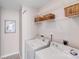 Well-lit laundry room with washer, dryer, and shelving for storage at 2213 Genesis Dr, Monroe, NC 28110