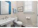 Charming half bath featuring a pedestal sink and decorative mirror at 2218 Croydon Rd, Charlotte, NC 28207