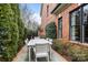 Outdoor dining area featuring a long white table and seating, surrounded by manicured greenery at 2218 Croydon Rd, Charlotte, NC 28207