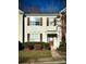 Front view of a light beige townhome with brown shutters and a walkway at 2711 Thornbush Ct, Charlotte, NC 28270