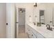 Well-lit bathroom featuring double sinks, white cabinets, tile flooring and a doorway to an adjacent room at 3013 Misty Moss Ct, Waxhaw, NC 28173