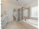 Bright bathroom with a glass enclosed walk-in shower, soaking tub and double sink vanity at 3013 Misty Moss Ct, Waxhaw, NC 28173