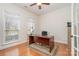 Sunlit home office featuring hardwood floors, large windows, and a classic desk at 3013 Misty Moss Ct, Waxhaw, NC 28173