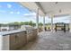 Outdoor kitchen with built-in grill, stone counters, and seating area at 3209 Whispering Creek Dr, Indian Trail, NC 28079