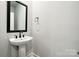 Clean powder room with pedestal sink and framed mirror at 3209 Whispering Creek Dr, Indian Trail, NC 28079